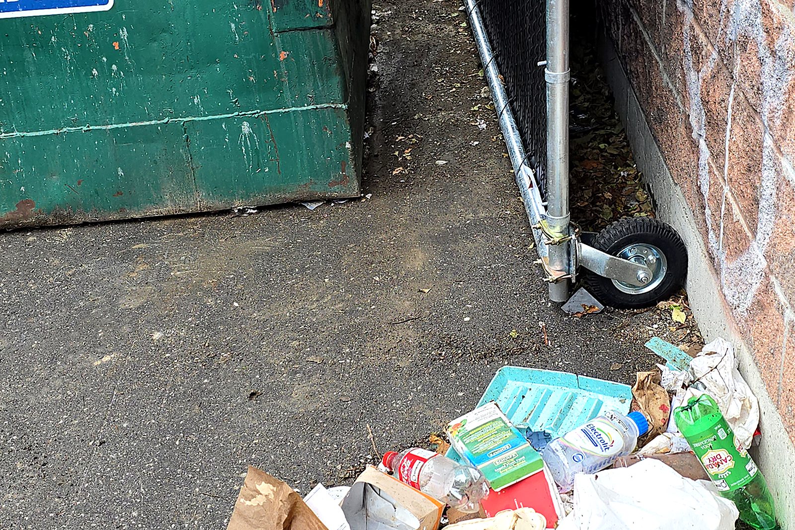 The same dumpster area with the litter raked out and gathered for removal