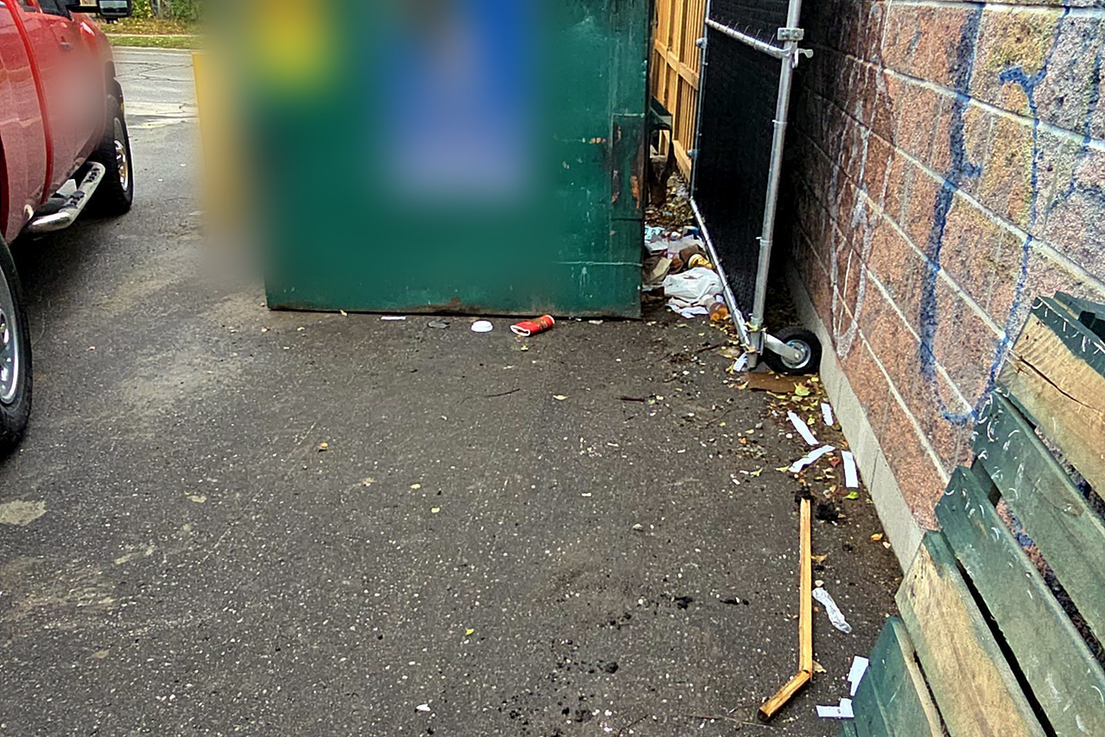 Litter scattered behind the dumpsters at a commercial property