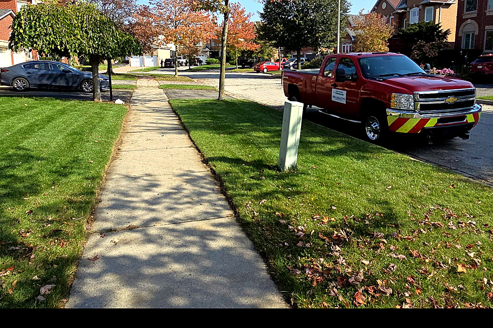 A residential front lawn cut and striped, with the walkway edged clean on both sides