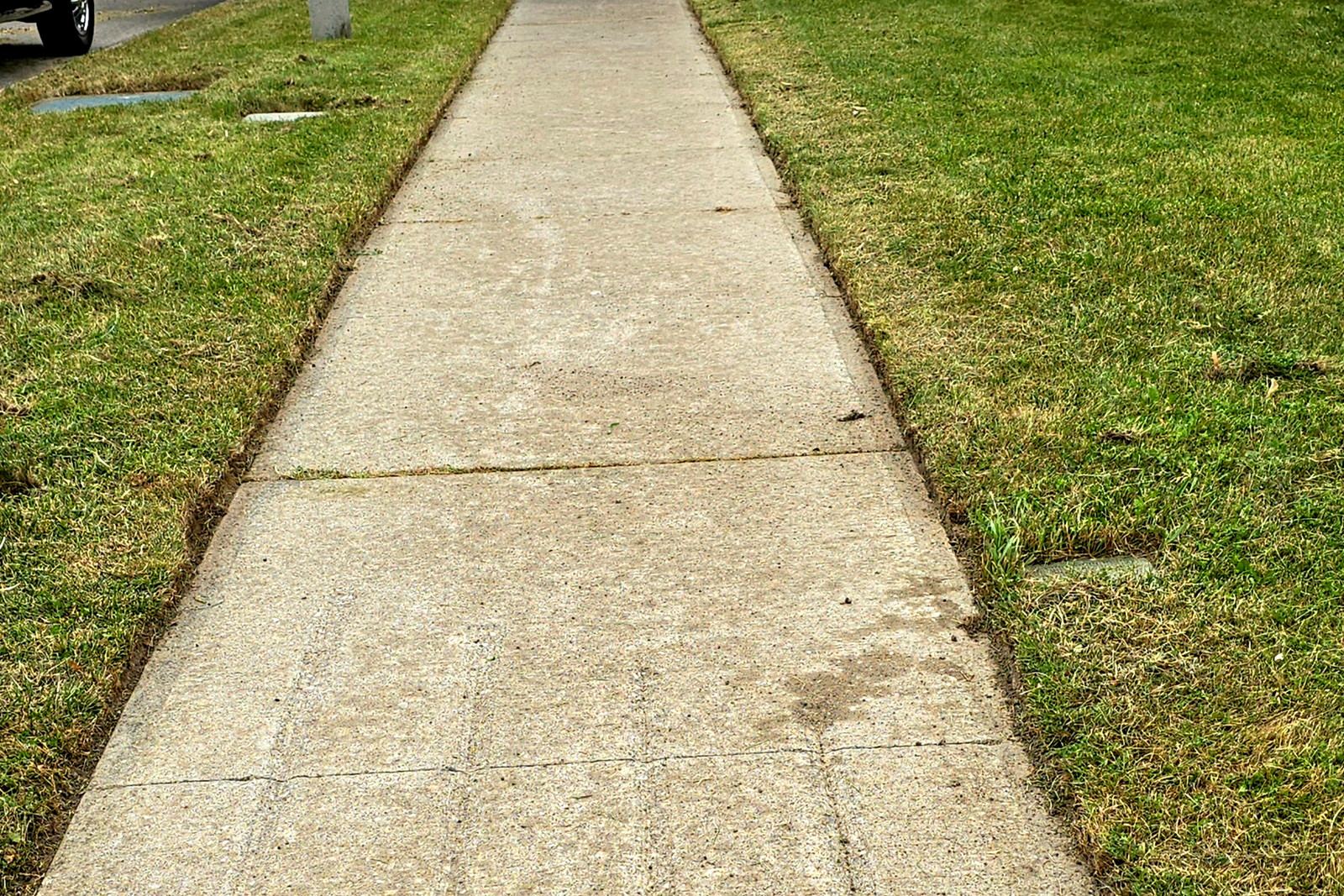 The same front walk after a Northline lawn cut, edged back on both sides