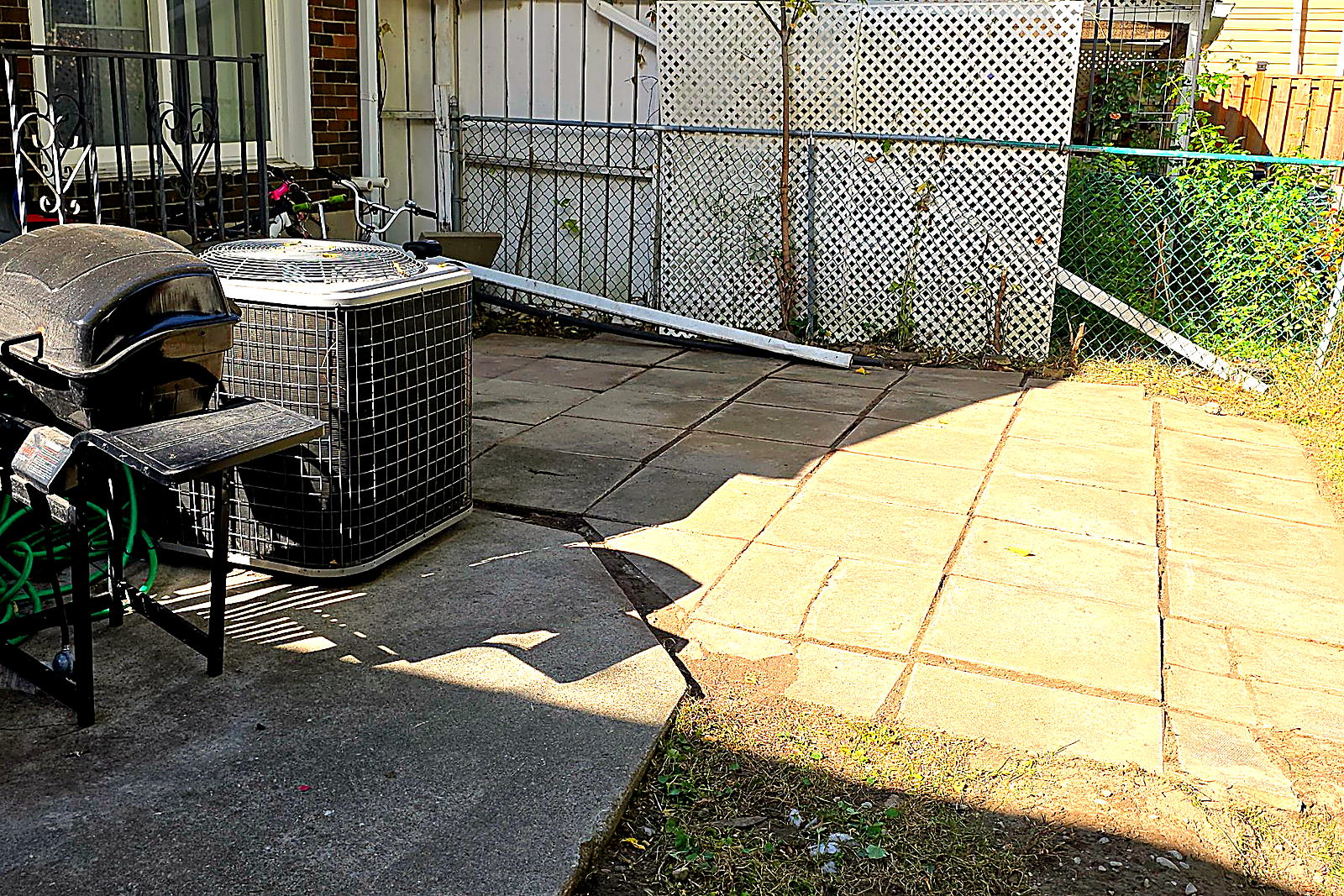 The same back patio cleared, the slabs swept and the edges cut back
