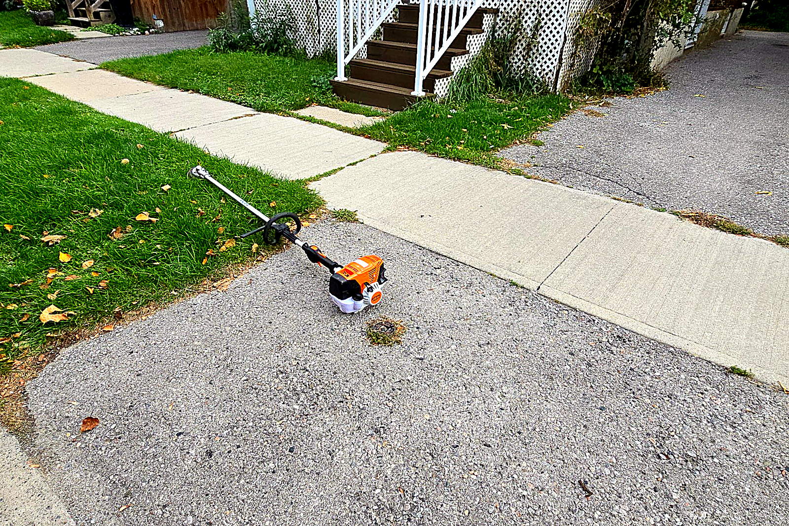 A driveway apron with grass grown over the concrete edge