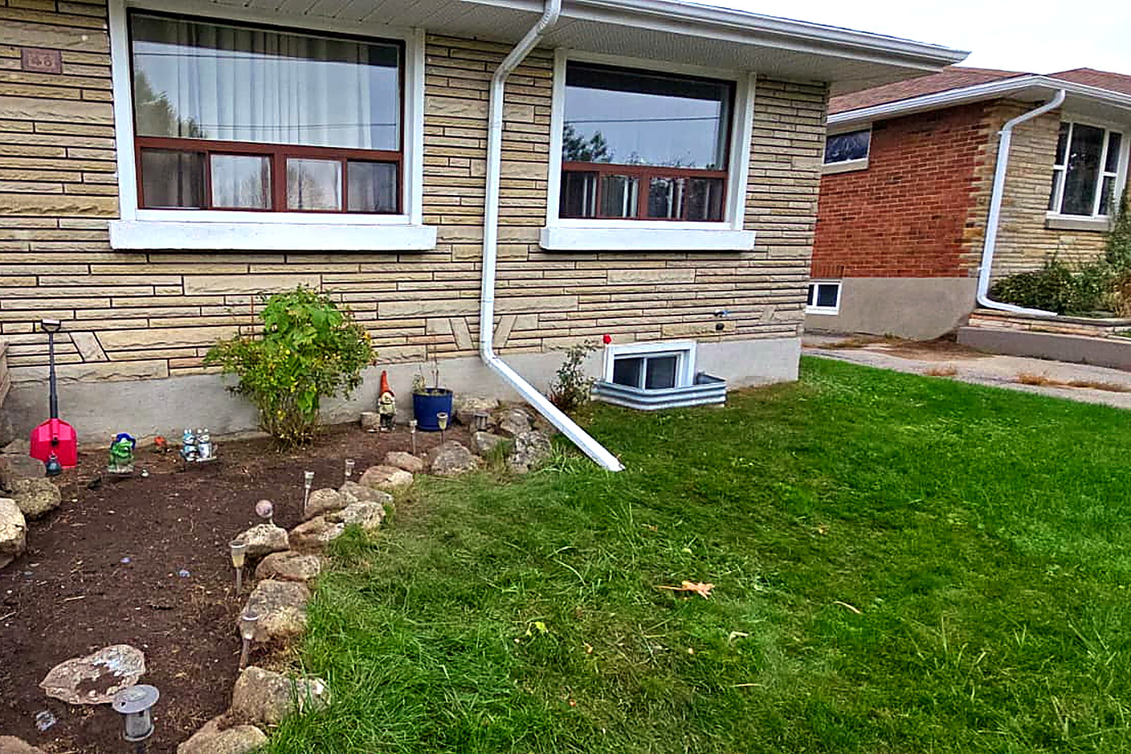The same front foundation bed cleared back to clean soil with the stone edging exposed