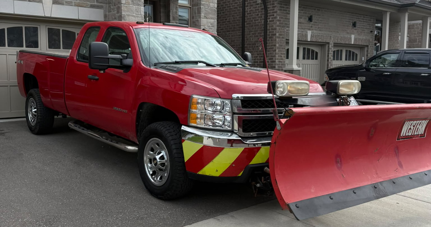 Red Northline Property Care truck with a Western plow mounted, on a driveway